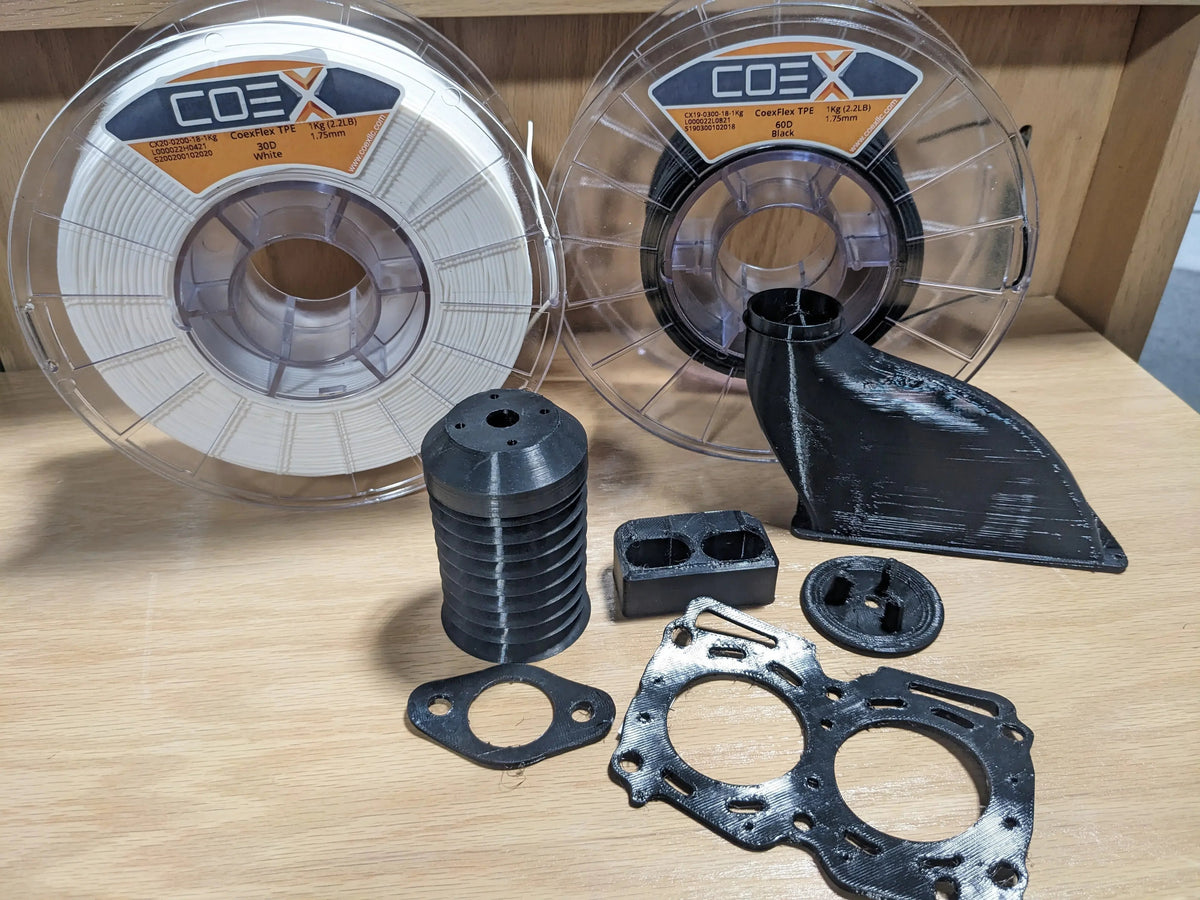 COEXFlex TPE 3D printer filament spools with black 3D printed parts on a wooden surface
