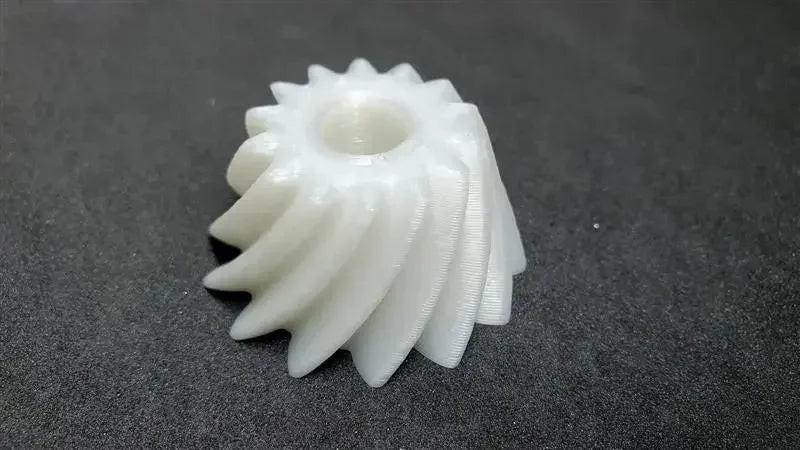 White 3D printed nylon gear on dark surface, CoexNylex unfilled filament