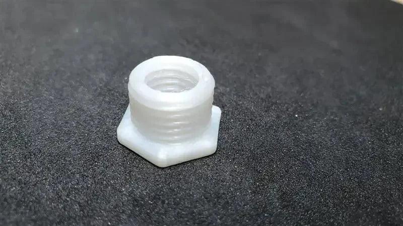 White unfilled nylon hex threaded insert on black background, 3D printed sample