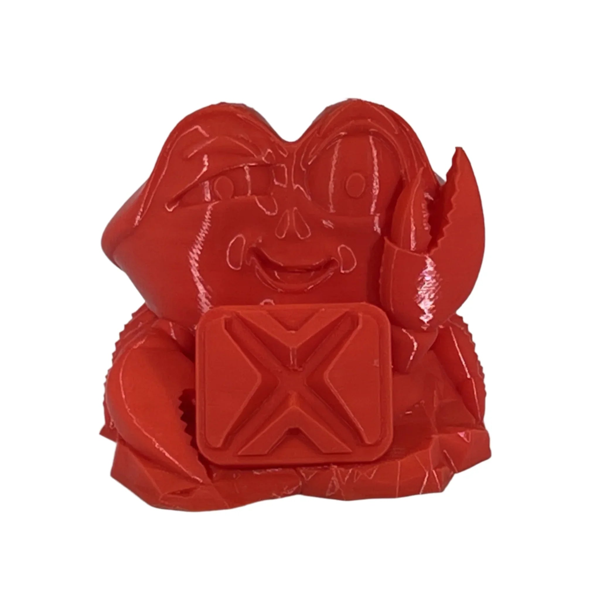 Red 3D printed crab figurine with a smiling face and holding a square object with an X symbol