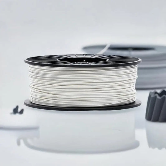 White 3D printer filament spool on a reflective surface with blurred background