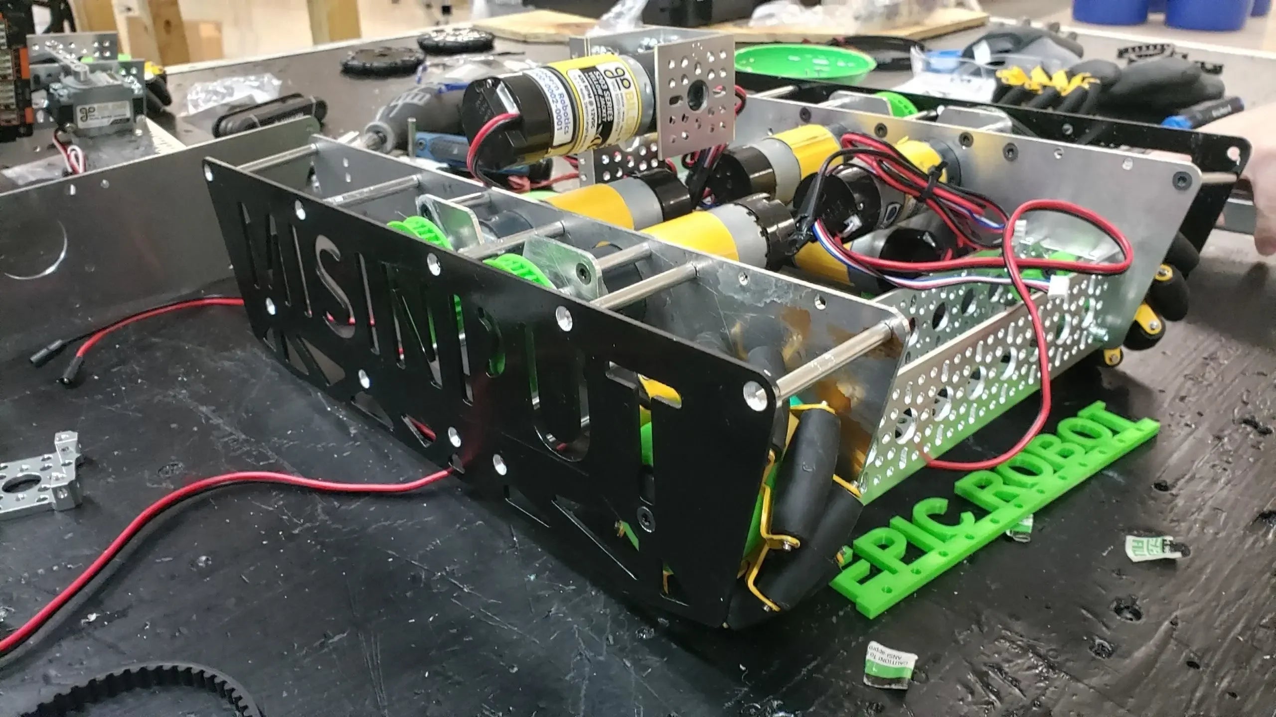 Custom-built robotics chassis with motors and wiring on a workshop table, labeled EPIC ROBOT