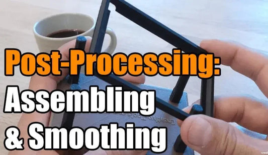 Hands assembling a 3D printed frame, post-processing, smoothing, coffee cup in background.