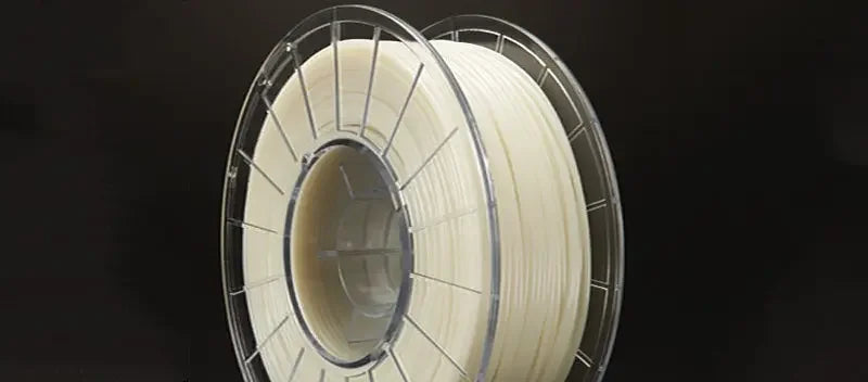 Clear spool of white 3D printer filament against a black background