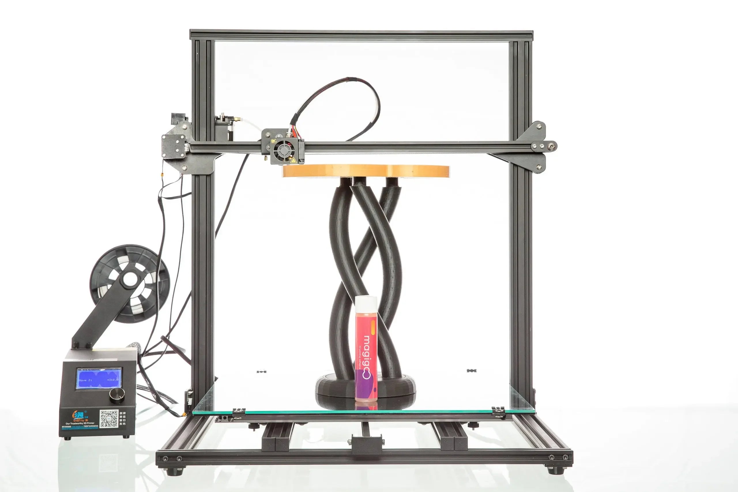 Magigoo Original 120ml 3D printing bed adhesive in front of a 3D printer with filament spool