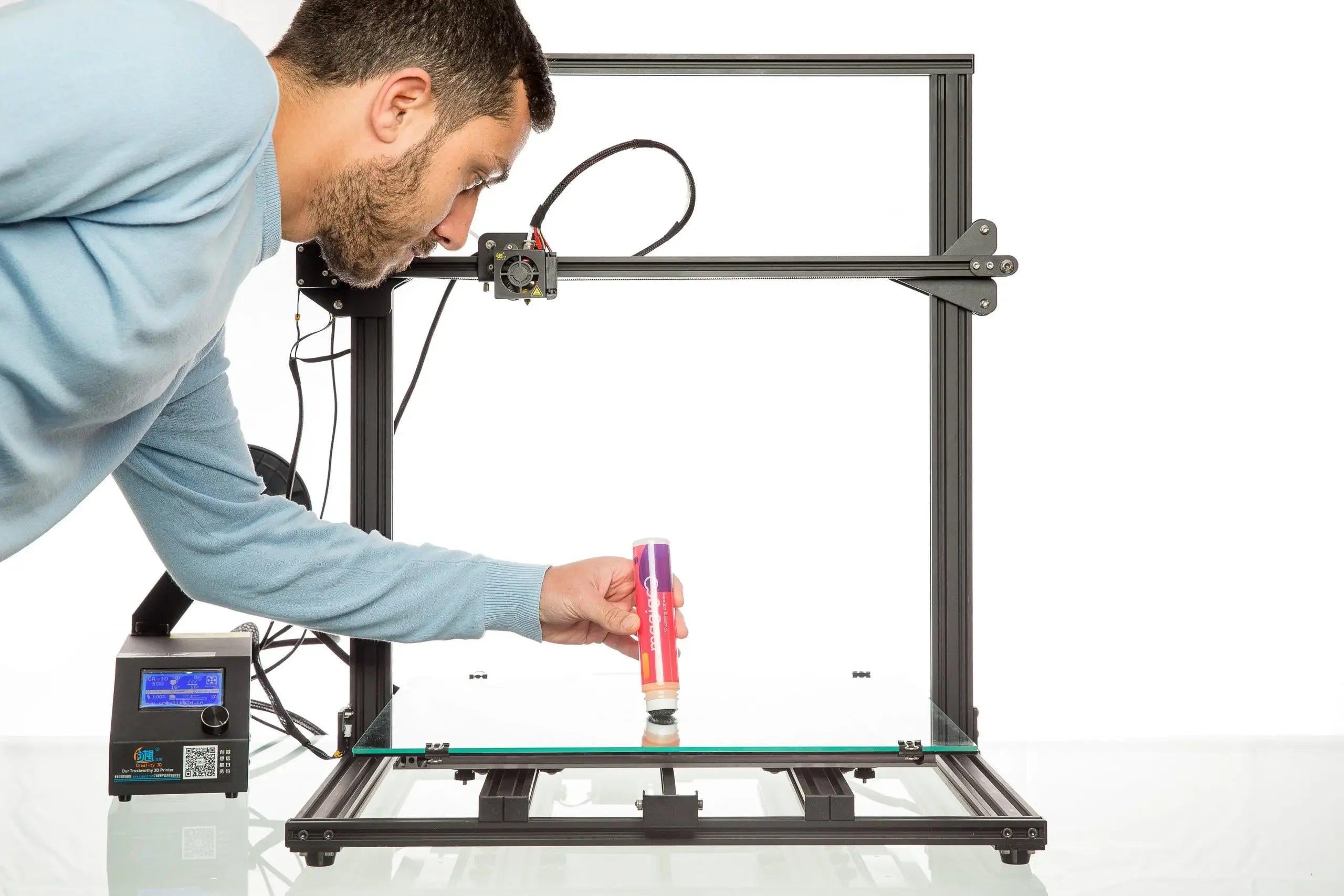 Man applying Magigoo Original 3D printing bed adhesive to a glass print bed